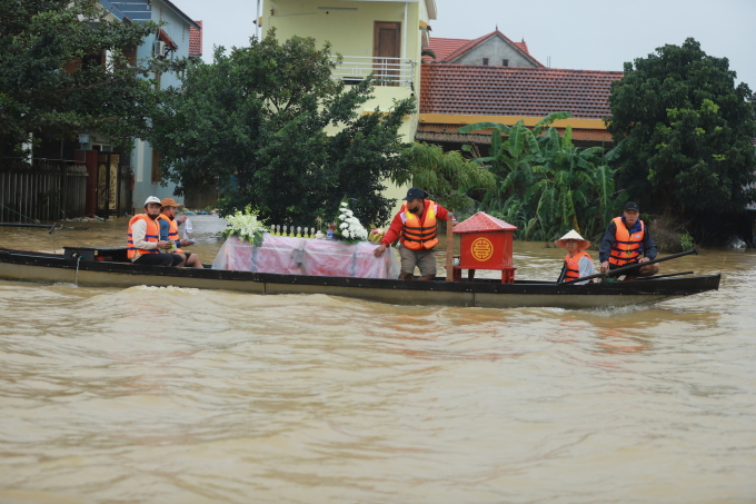 Người dân thị trấn Kiến Giang đưa tang trong lũ. Ảnh: Võ Thạnh