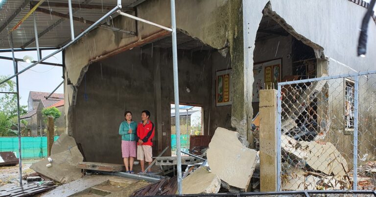 2 vợ chồng đứng thất thần bên căn nhà bị sóng lũ đánh sập ở Quảng Bình