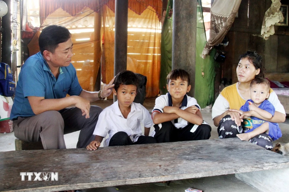 Thầy Hoàng Xuân Dục thường xuyên đến nhà vận động học sinh tới trường lớp đều đặn. (Ảnh: Tá Chuyên/ TTXVN) TTXVN_1911 thay giao dan toc Chut 3.jpg