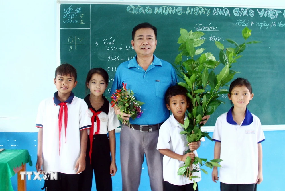 Thầy Hoàng Xuân Dục luôn cảm thấy vui với những nhành hoa dại, bó chè tươi của học sinh giành tặng Thầy trong ngày Nhà giáo Việt Nam 20/11. (Ảnh: Tá Chuyên/ TTXVN) TTXVN_1911 thay giao dan toc Chut 4.jpg